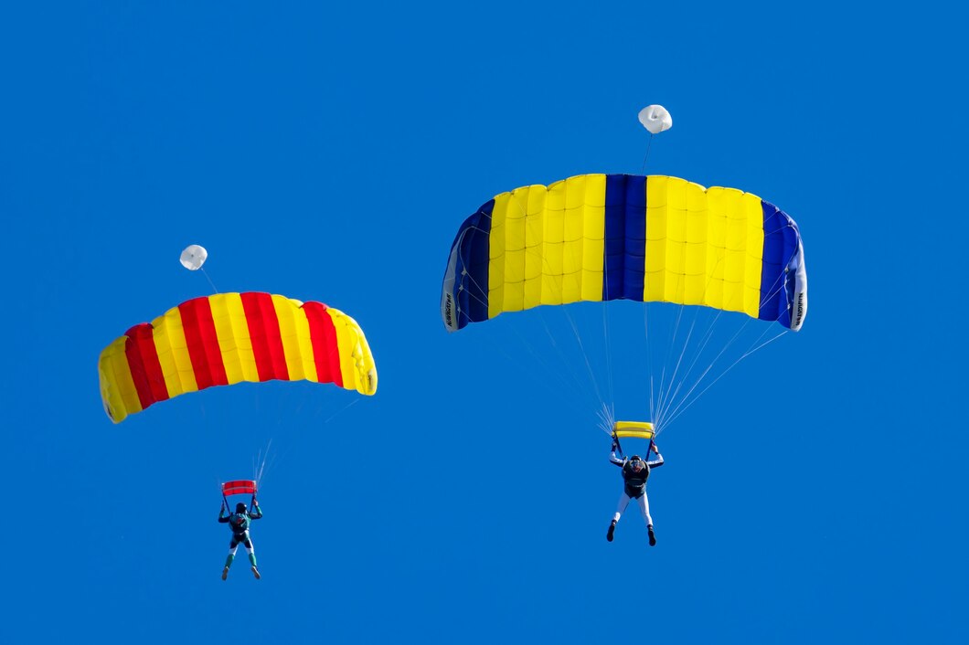 two-parachutists-against-blue-sky_268835-3456