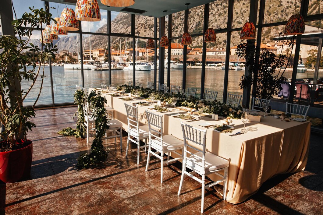 wedding-reception-room-with-decorated-table-setting-sea-view-through-window_637285-984